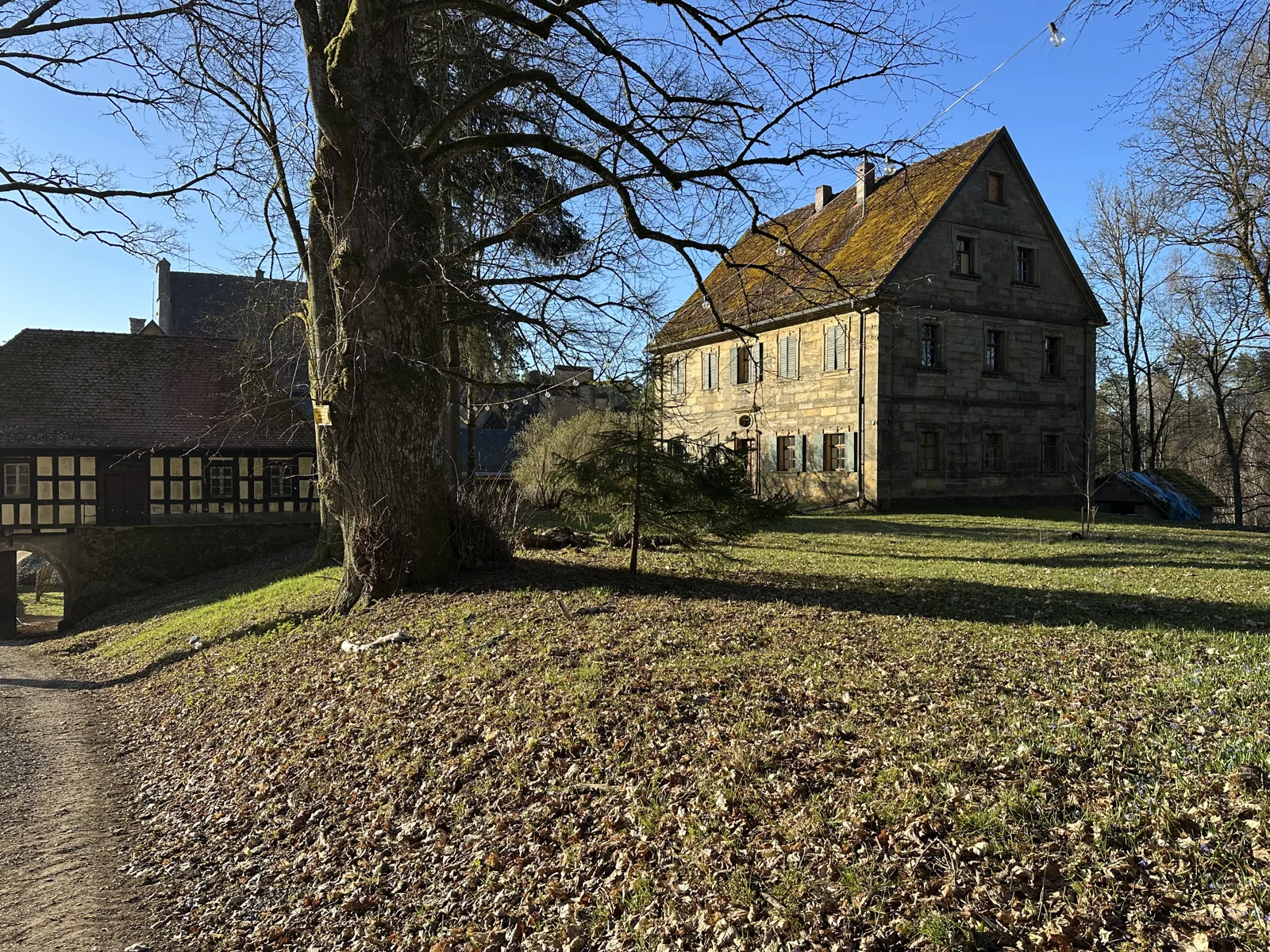 Das ehemalige Forsthaus mit Steingiebel, Wiese und altem Baumbestand
